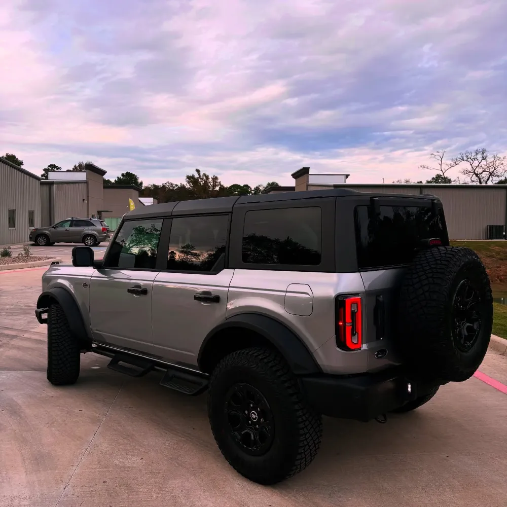 Rear view of a silver Ford Bronco displaying vinyl wraps in Stagecoach TX